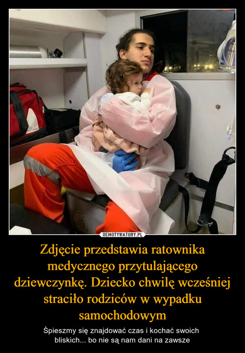 Zdjęcie przedstawia ratownika medycznego przytulającego dziewczynkę. Dziecko chwilę wcześniej straciło rodziców w wypadku samochodowym